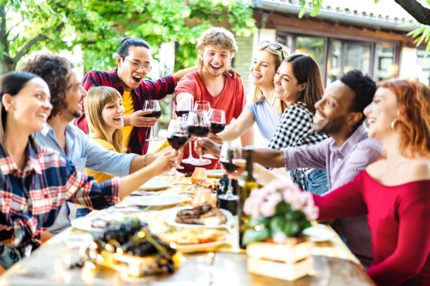 Happy friends having fun toasting wine outside at a lunch