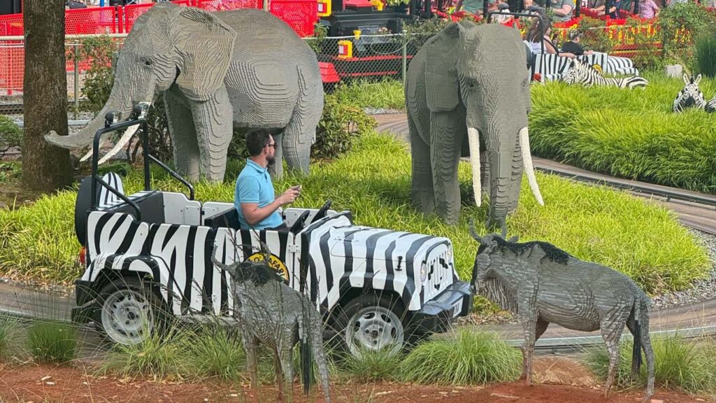 Man driving a safari car through the Lego safari animals at Legoland Billund