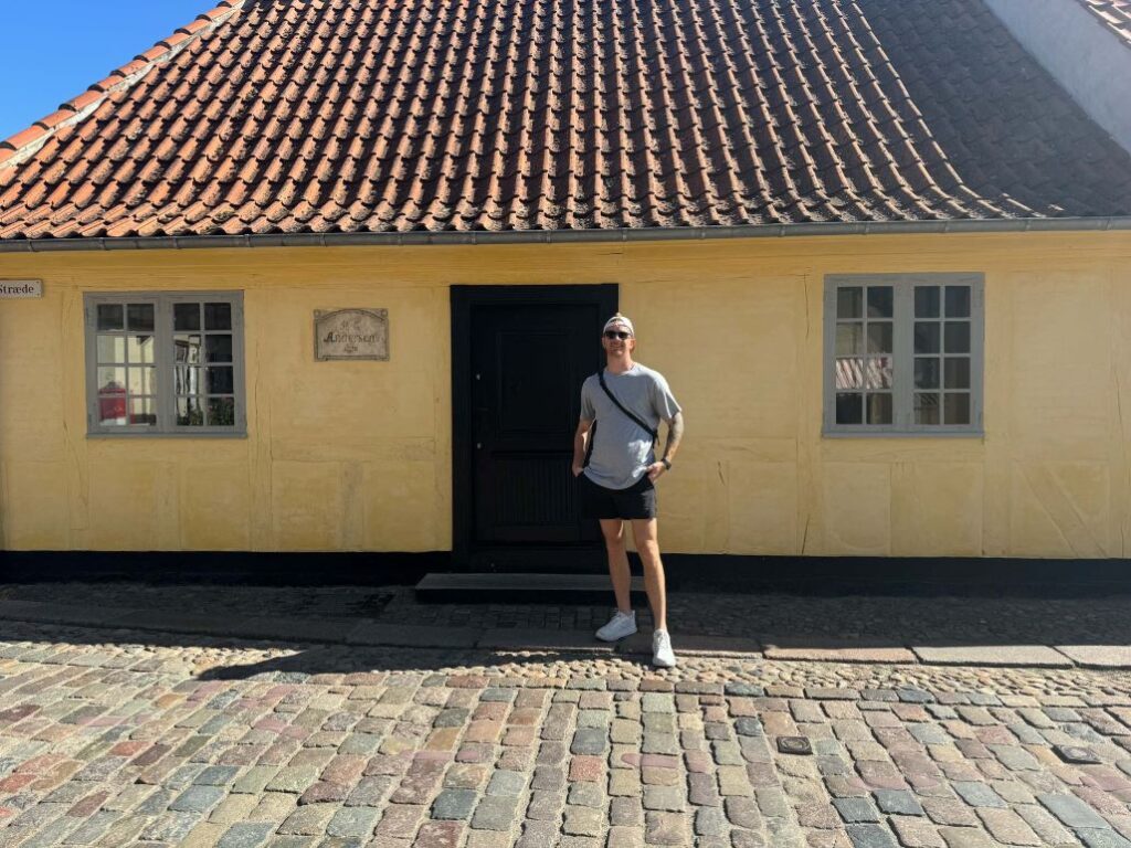 Man standing in front of Hans Christian Andersen's house in Odense, Denmark