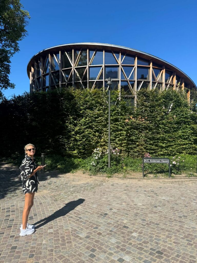 Woman standing in front of Hans Christian Andersen Museum in Odense, Denmark