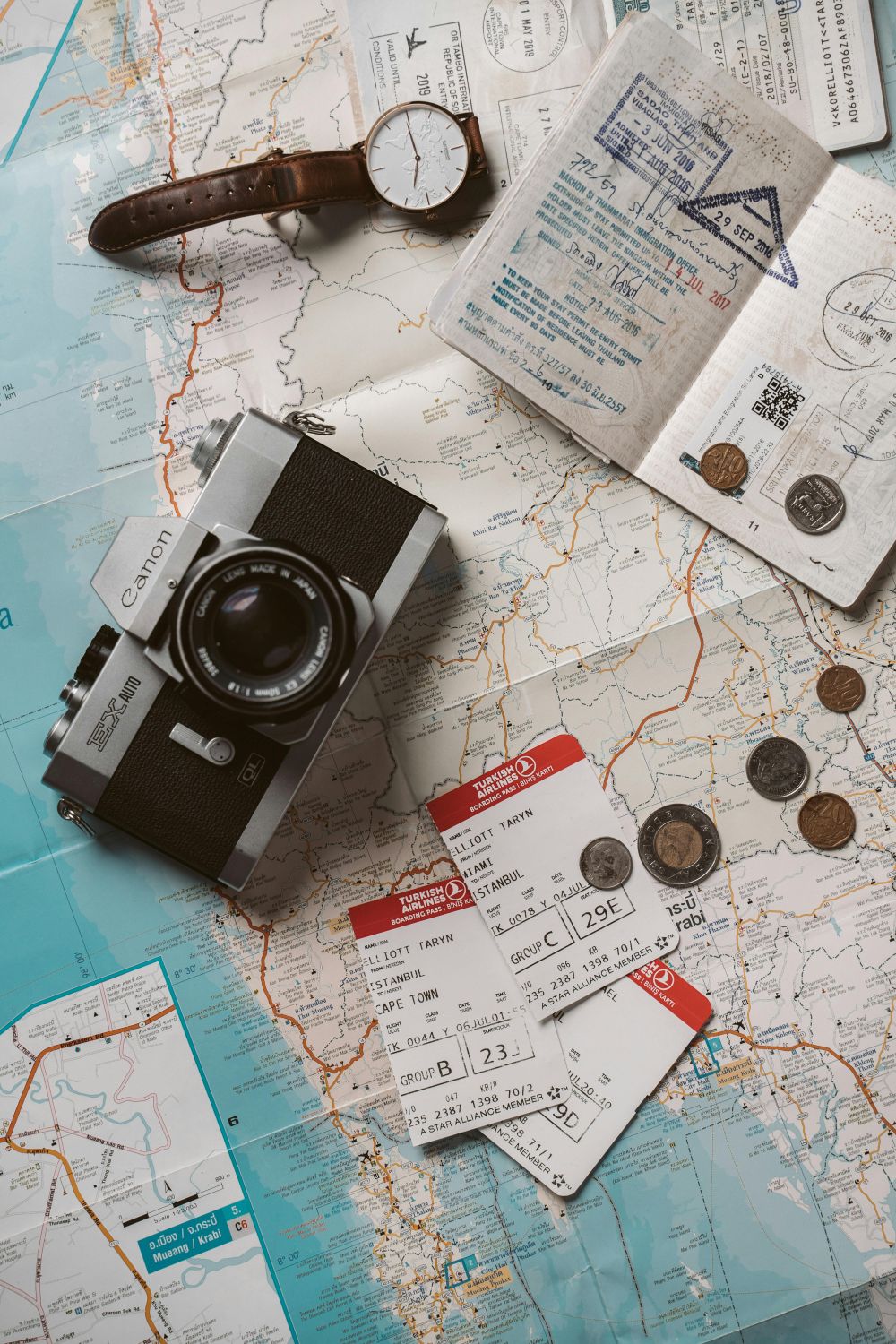 Passport, Camera, Watch , Money and Boarding Passes on a map