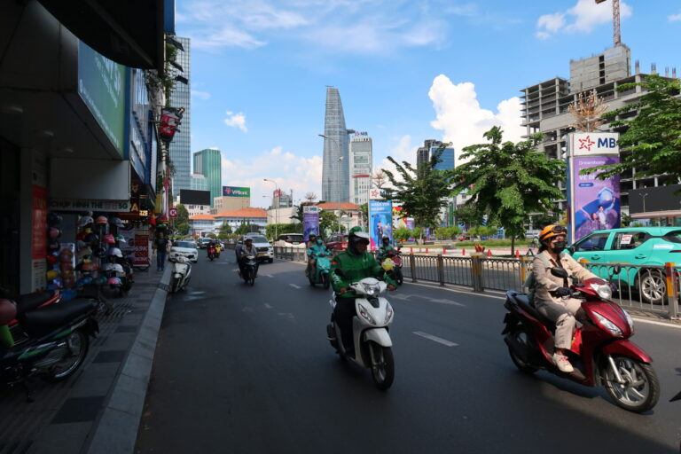 Ho Chi Minh City street photo with motorbikes and the saigon skyscrapers in the background