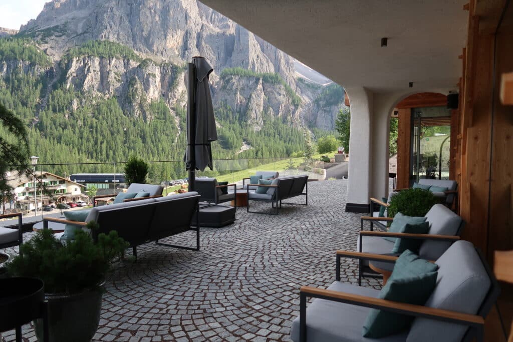 Outdoor tables and chairs overlooking the mountain view at Hotel Recort in Italy