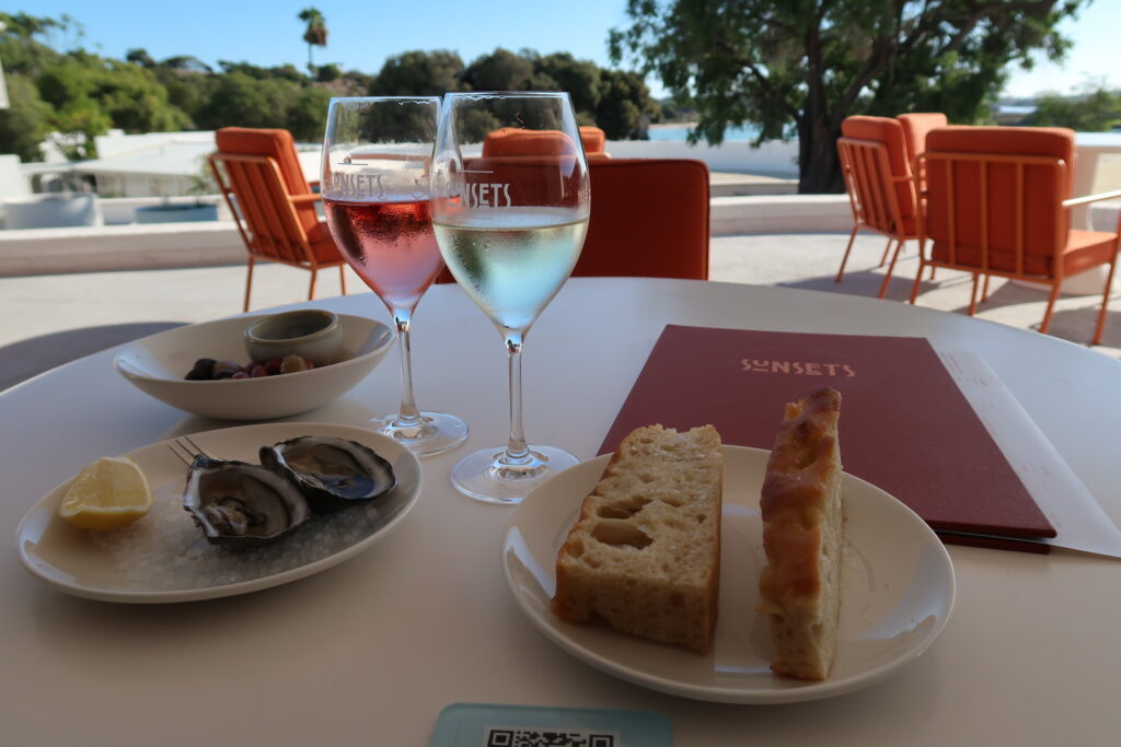 Oysters, foccaccia and wine glasses on the patio at Sunsets Bar and Dining Restaurant