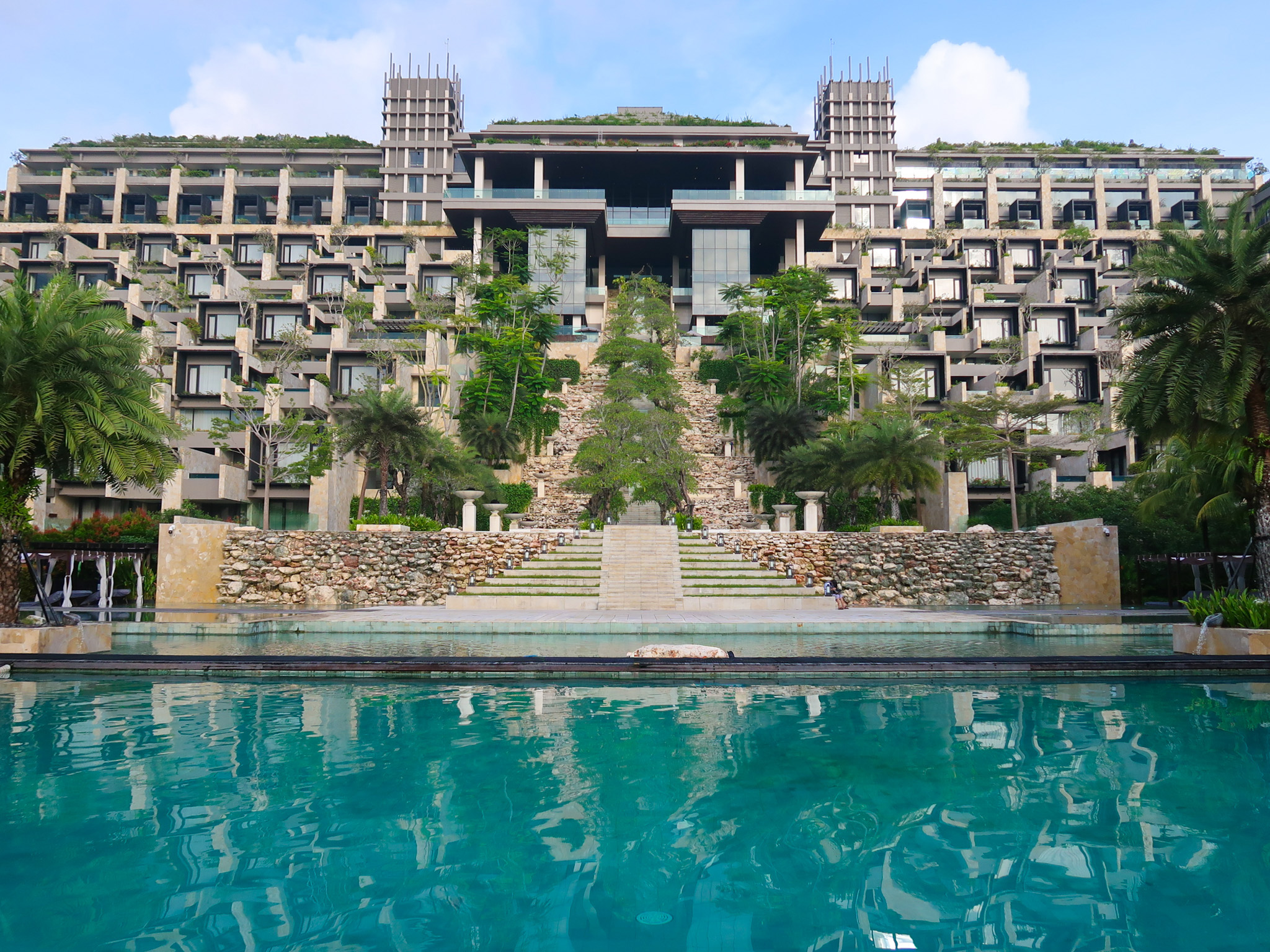 The Apurva Kempinski Bali grand staircase, pool and tiered hotel rooms