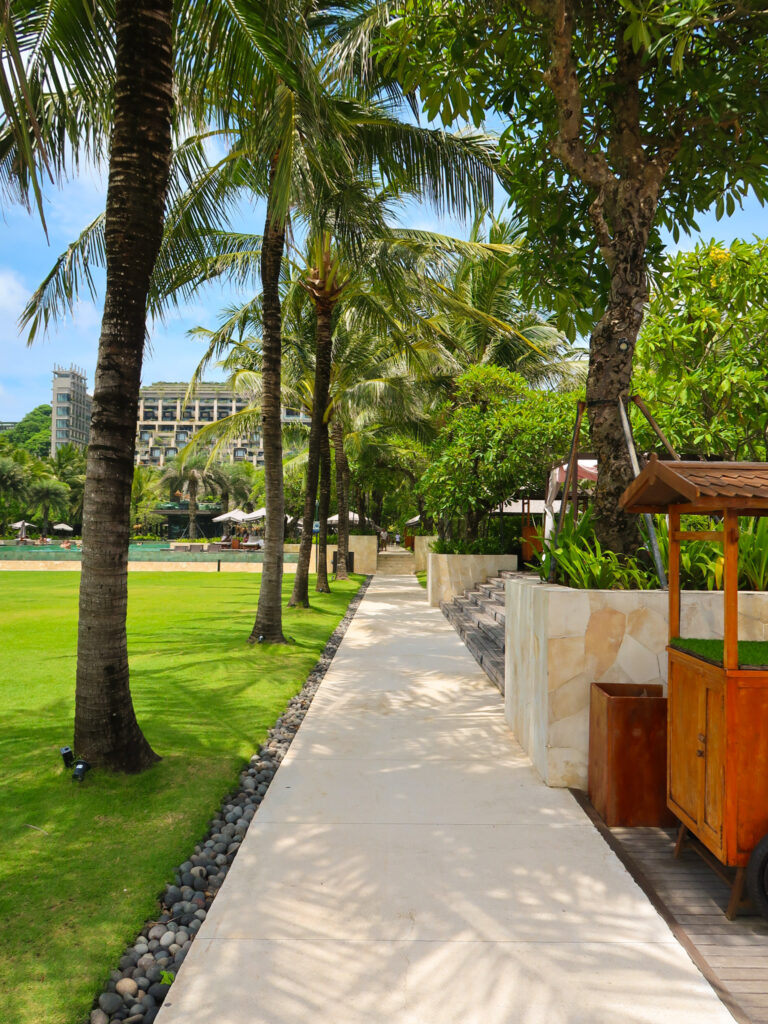 Palm tree lined pathway near the pool for The Apurva Kempinski Bali review